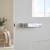 High-shine polished chrome Carlina on Hidden Rosette minimalist internal door handles with a mirror-like reflective finish on a bright white door.