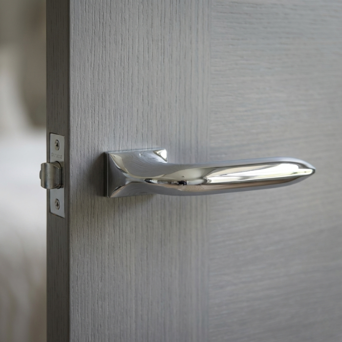 Gladiola - Polished Chrome Gladiola on Hidden Rosette hidden rosette internal door handles in a brilliant polished chrome finish, featuring a sleek tapered design on a light grey timber door.