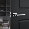 High-shine polished chrome exclusive rectangle door handles from the Ismena collection, creating a striking reflective accent on a dark charcoal grey door.