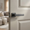 Sophisticated graphite Pina on Square Rosette elegant square internal door handles in a dark grey metallic tone on a light grey timber door.