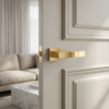 Luxurious polished gold elegant square internal door handles from the Pina range, mounted on a classic white interior door for a sophisticated look.