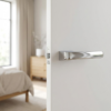 High-shine polished chrome Plumeria on Hidden Rosette hidden luxury internal door handles with a reflective mirror finish on a bright white interior door.