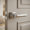 Mirror-finish polished chrome Raflesia on Square Rosette high-end square door handles mounted on a contemporary light grey wood grain door.
