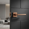 Setia on Square Rosette classic square internal door handles in a unique PVD copper finish, providing a warm metallic accent on a modern black door.