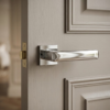 High-shine polished chrome Stella on Square Rosette sophisticated square door handles featuring a reflective mirror-like finish on a light grey timber door.