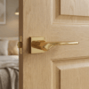 Bergenia on Square Rosette in PVD gold, a luxurious elegant door handle for internal doors set against a light oak door.