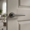 Sleek curved door handle in graphite finish, Euphorbia on Round Rosette, fitted to a light wood internal door.