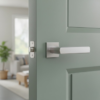 Contemporary square internal door handles in satin chrome, featuring the Fresia lever on a square rosette mounted on a softly coloured interior door.