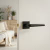 Minimalist square door handles with the Funkia design on a square rosette in matt black, shown on a white internal door for a clean contemporary look.