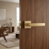 Designer square door handles – Hosta on Square Rosette in matt gold finish on a dark wood door, adding a warm, contemporary accent with a square backplate.