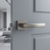 Designer square door handles – Hosta on Square Rosette in titanium finish on a modern grey door, delivering a sophisticated industrial look with a square backplate.