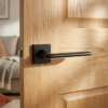 Lila on Square Rosette minimalist square internal door handles in a bold matt black finish on a natural oak door.