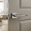 Mirror-finish polished chrome Lunaria on Square Rosette premium square internal handles installed on a light grey timber internal door.