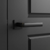 Mela on Square Rosette timeless square internal door handles in a smooth matt black finish, mounted on a matching dark charcoal door for a seamless look.