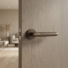 Molinia on Round Rosette brown door handle fitted to a warm wood grain door, emphasising understated round door handles for contemporary homes.