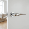 Petunia on Round Rosette in polished chrome, showcasing sculpted round door handles on a white interior door.