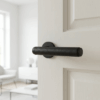 Egeria on Round Rosette in matt black with black leather grip, featuring premium internal door handles on a white interior door.