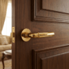 Ficaria on Round Rosette in polished gold, highlighting elegant brass door handles on a rich wooden door for a luxurious interior look.